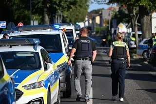 Police officers walk near the private Docemus school on Thursday, where two people were killed. Photo: AFP