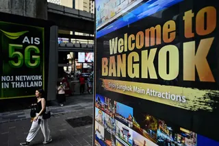 This photo taken on March 17, 2023 shows a woman walking past a sign highlighting tourist attractions in Bangkok. Thailand’s government has warned that ‘problematic’ tourists could face deportation as new rules on removing foreigners convicted of illegal activities came into today. — AFP pic