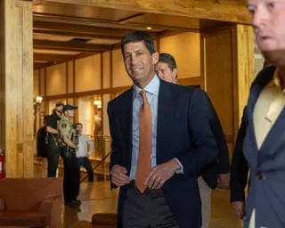 A man in a suit walks in a corridor
