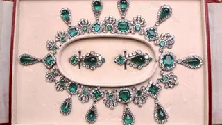 The spectacular emerald earring and necklace set laid out in a display case