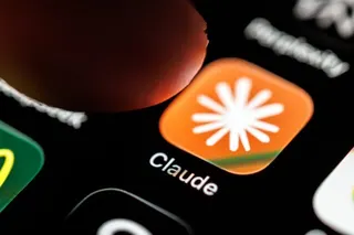 A person's finger hovering over the Claude AI app's icon on a phone screen.