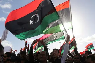 FILE PHOTO: People wave Libyan flags during a demonstration in Benghazi February 7, 2014. REUTERS/Esam Omran Al-Fetori/File Photo