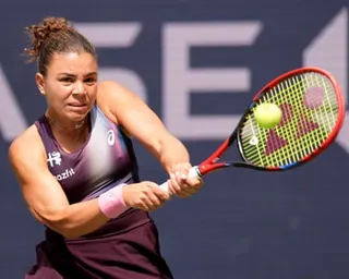 Jasmine Paolini hits a backhand shot with her racket close to the ball