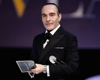 a man in a suit holds a microphone