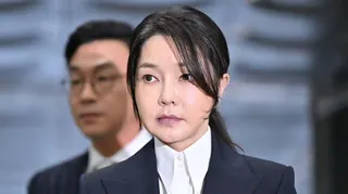 Kim Keon Hee, in a white dress suit and black blazer, arrives in court in Seoul to attend a hearing