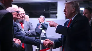 President Donald Trump (R) speaks to Apple CEO Tim Cook (L) as he attends a reception for business leaders at the World Economic Forum (WEF) Annual Meeting on January 21, 2026 in Davos, Switzerland.