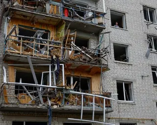 A woman looks out of a window of her apartment damaged by a Russian missile strike in the town of Boryspil, amid Russia’s attack on Ukraine, in Kyiv region, Ukraine.