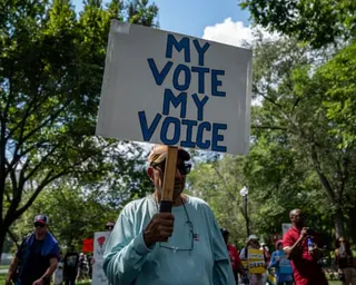 A man holding a sign that says 'My vote, my choice.'