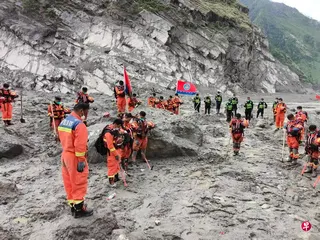 西藏自治区星期二（9月1日）上午9时55分在日喀则市公安局吉隆口岸分局举行遇难者哀悼活动，泥石流灾害救援现场、道路抢通现场等同步举行，多方人员、地方干部群众等参与哀悼活动。图为救援人员在救灾最前沿的口岸区域默哀。 （新华社）