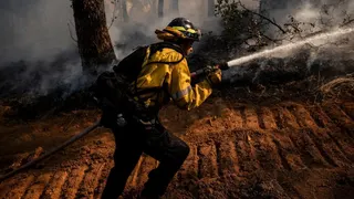 Firefighter Avery Stark, of Cal Fire’s Tuolumne-Calaveras Unit, soaks the ground next to a bulldozer-cut containment line while battling the Gann Fire near Angels Camp on Tuesday, August 4, 2026.