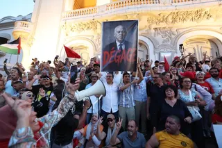 epa13181359 Tunisians hold the photo of Tunisian President Kais Saied and shout slogans during a demonstration against Saied and deteriorating living conditions, under the slogan, 'Enough of the absurdity, enough of the failure, enough of the injustice,' in Tunis, Tunisia, 20 August 2026. The demonstration, organized by the National Salvation Front and the Nafas movement, bought together opposition members and citizens denouncing the country's political, economic and social situation. EPA/MOHAME