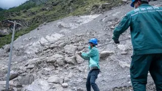 周四，在西藏自治区吉隆泥石流灾害核心区，电力工人在放导线。（图取自新华社）