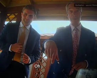 Nigel Farage and a colleague stand under a pavilion in secretly filmed footage