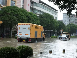 应急车辆在福建闽侯县受淹浸的街道行驶。（图取自新华社）