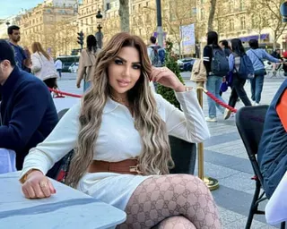 Sarah Khalifa posing for a photo at a cafe table