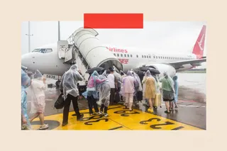 A group of people in clear waterproof ponchos boarding a plane