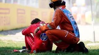 Charles Leclerc is consoled by a marshal after his high-speed crash at Monza