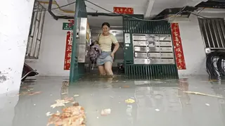 2026年8月9日，上海市長寧區紫雲路聯建新村，受颱風白海豚影響，上海普降大雨，市民涉水行走（中新社圖片）