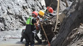 9月5日，在西藏自治区吉隆县受灾核心区，施工人员装填石块加固道路。（图取自新华社）