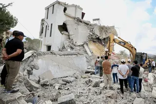 People inspect the destruction caused by an Israeli air strike in Arab Salim, southern Lebanon on Sunday. Photo: EPA