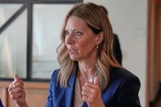 person wearing blue jacket gestures while speaking