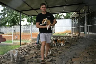 7月28日，Dognosis联合创始人比坦抱著一只狗，站在位于班加罗尔郊区肯波哈利村的Dognosis公司犬舍内。（图取自法新社）
